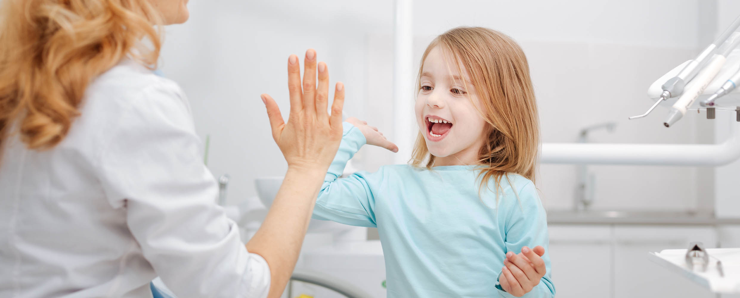 Child giving her dentist a high-five after a dental exam Maricopa, AZ
